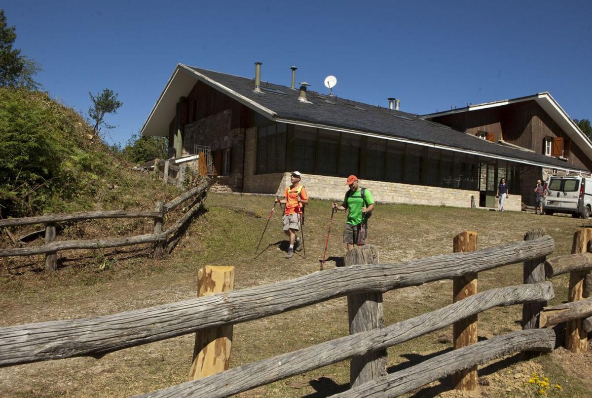 Senderistas en Brañagallones, en el Parque Natural de Redes, con el refugio al fondo. | FERNANDO RODRÍGUEZ