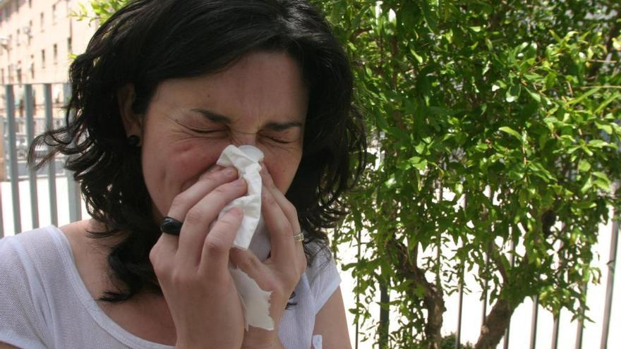 Una chica se cubre la boca al estornudar por los efectos de la alergia.