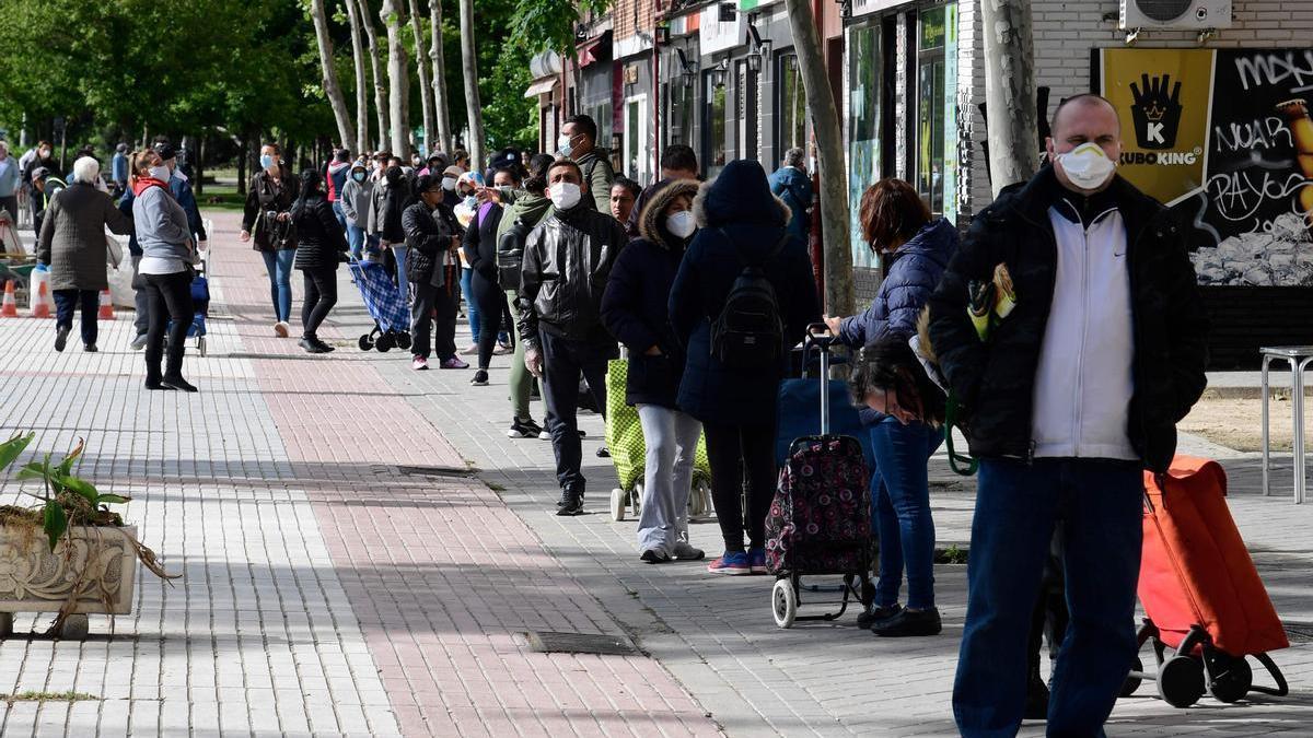 Varias personas se unen a las ’colas del hambre’ de Aluche para recoger comida, en mayo de 2020.