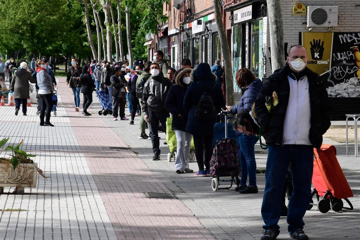 Varias personas se unen a las ’colas del hambre’ de Aluche para recoger comida, en mayo de 2020.