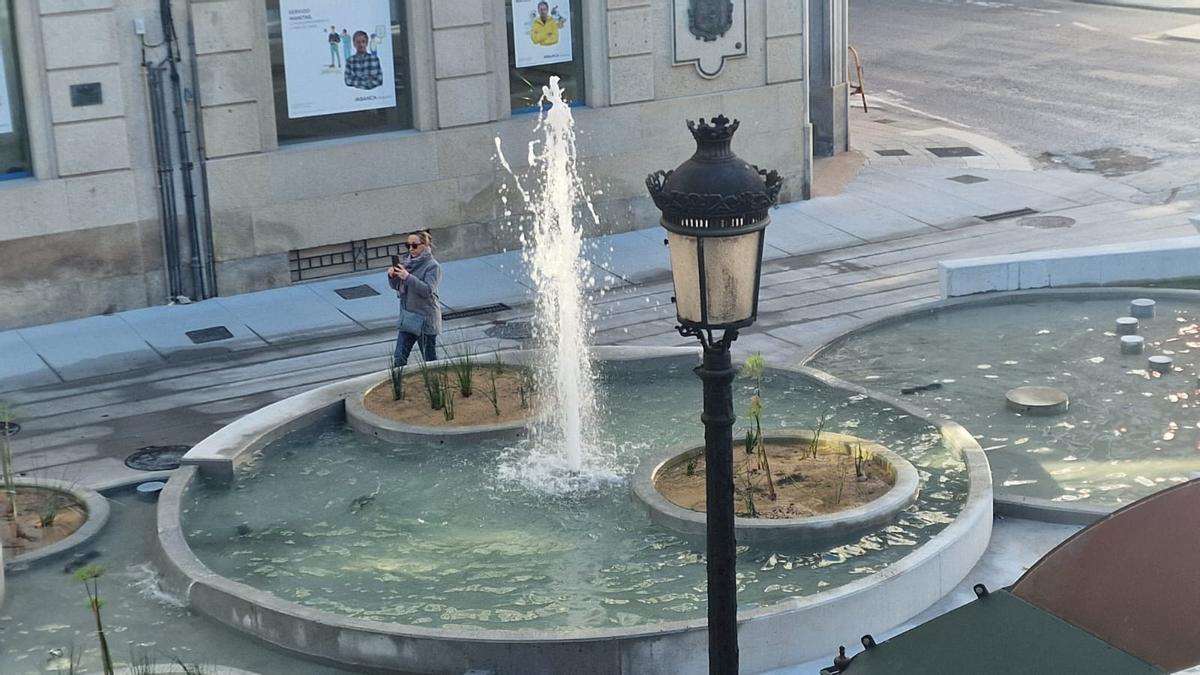 Una mujer tomando imágenes de las fuentes, ayer.