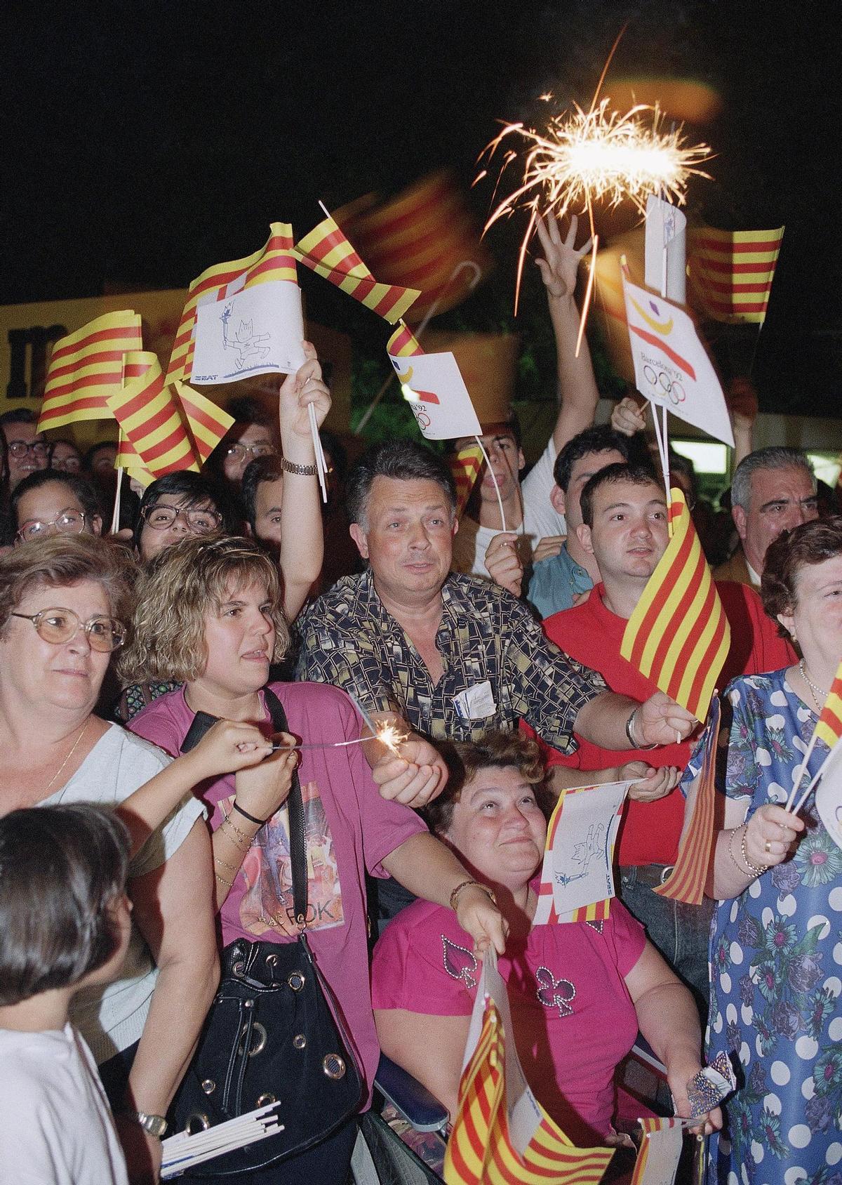 Público emocionado en la calle, con banderas de Catalunya y de los Juegos Olímpicos, durante la celebración del evento en verano de 1992.