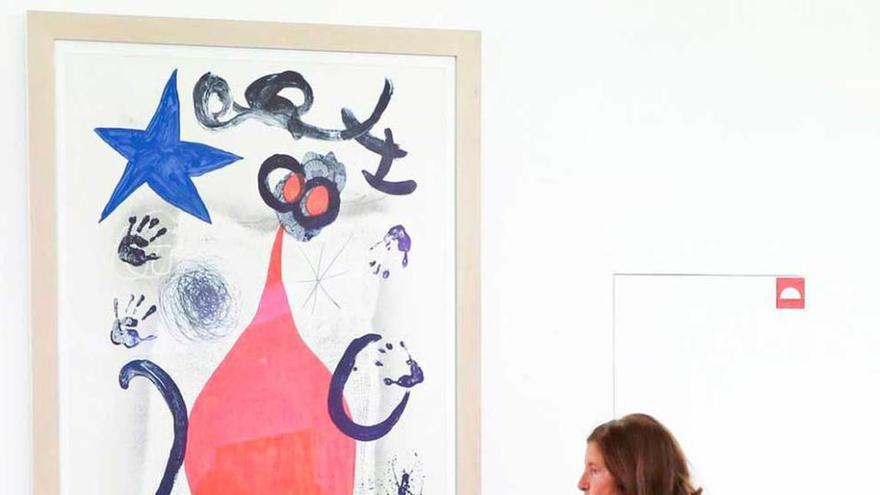 Una madre muestra a su hijo una obra de Miró en el museo.