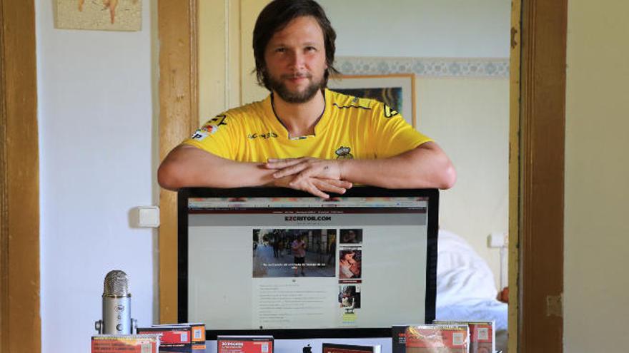 Rafael Fernández, con una camiseta de la UD, se apoya en la pantalla donde muestra su web.