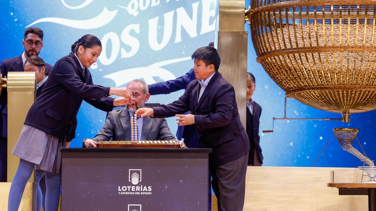 Los niños de la Residencia San Ildefonso de Madrid Piero Rai Chávez (d) y Alisce Ríos (i), muestran el número 72.480, el Gordo de Navidad, dotado con 4.000.000 euros a la serie y 400.000 euros al décimo, durante el sorteo de la Lotería de Navidad que se celebra este domingo en el Teatro Real, en Madrid.