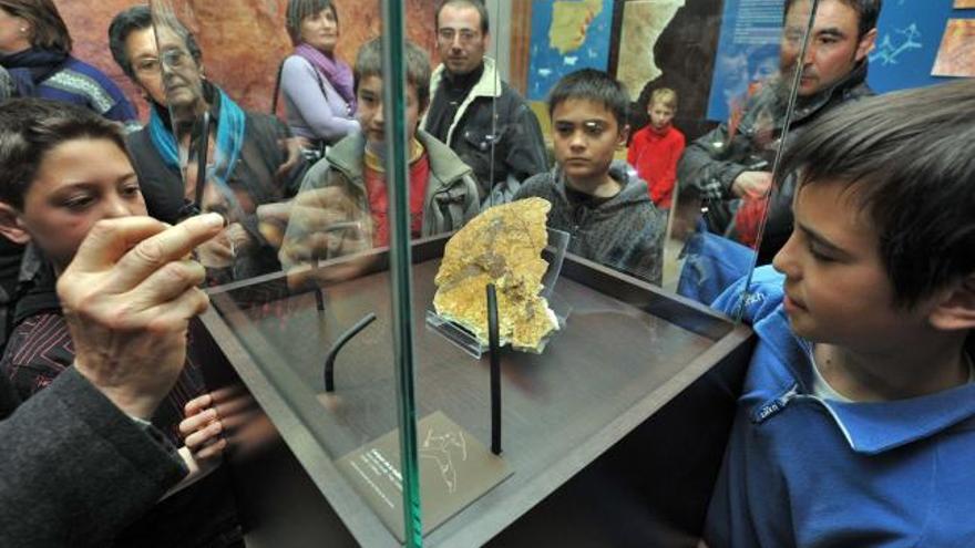 Varios niños observan la pieza, ya en su vitrina del museo.