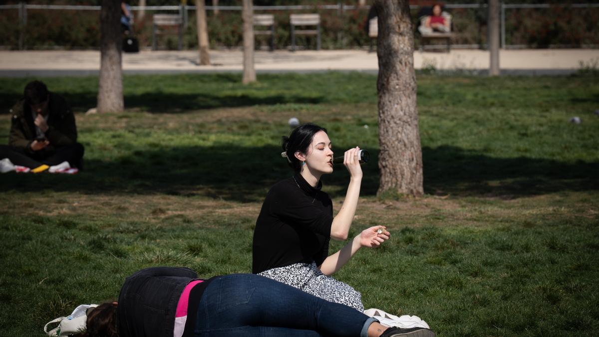 Jóvenes disfrutan del buen tiempo en un parque.