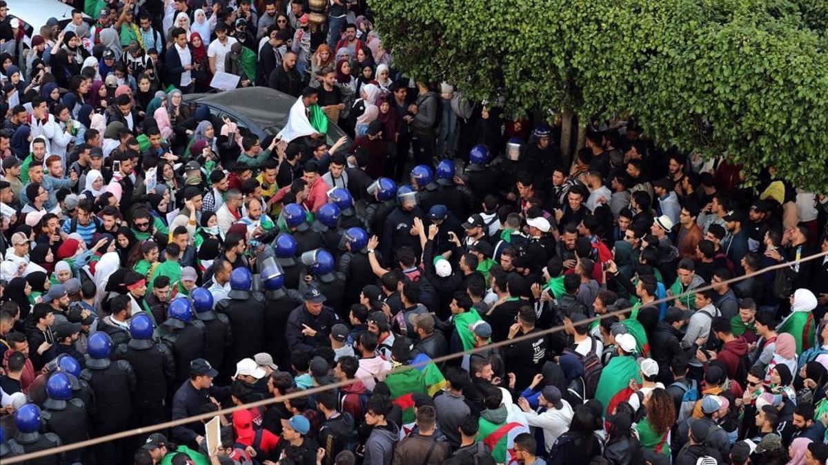 Un cordon policial separa a dos grupos de estudiantes argelinos que protestan contra la decision del presidente del pais  Abdelaziz Buteflika  de optar a un quinto mandato.