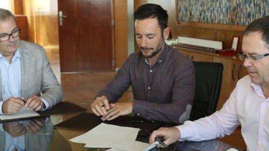Los alcaldes Rafa Ruiz y Josep Marí Ribas firman un documento ante la mirada de Vicent Torres.