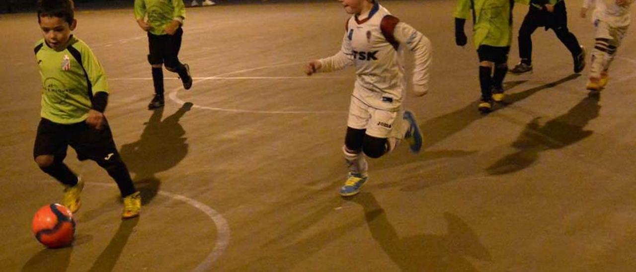 Un joven futbolista del Jove conduce el balón en su encuentro ante la Escuela de Fútbol de Roces.