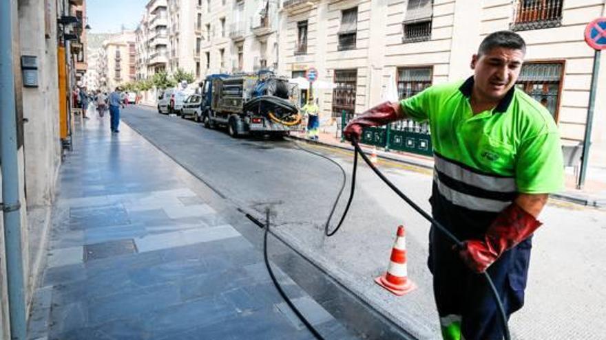 Un operario limpiando un imbornal.