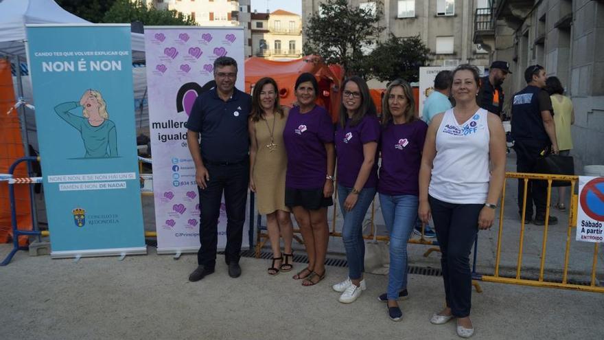 El alcalde de Redondela, Javier Bas, y la edil de Igualdade, Teresa París (dcha.), con el personal del stand de Mulleres en Igualdade durante el &quot;Entroido de Verán&quot;. / FdV