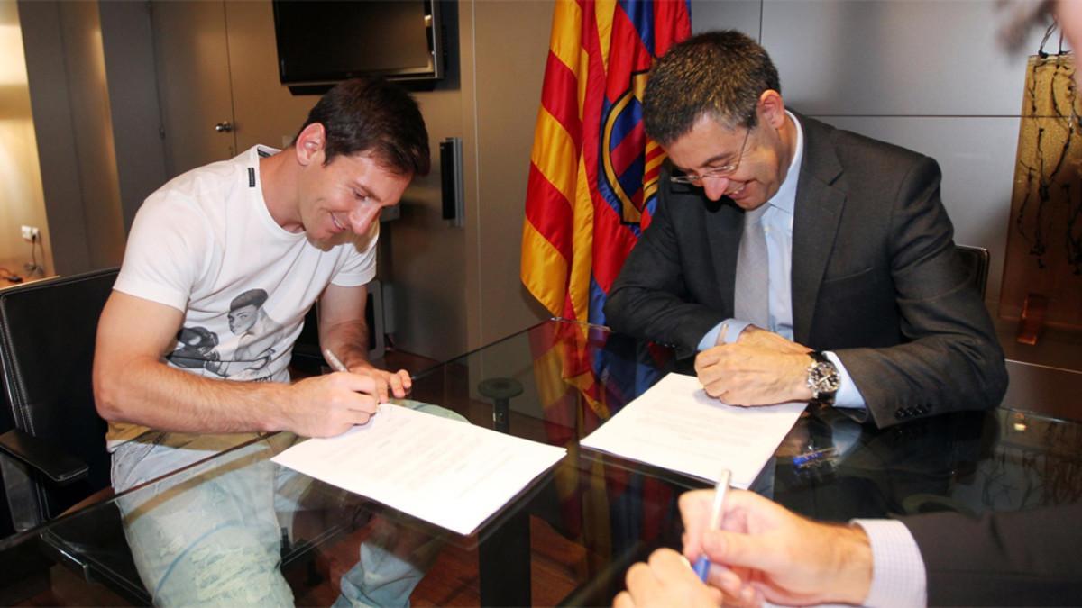 Leo Messi y Josep Maria Bartomeu, duranmte la firma de la renovación del argentino el 19 de mayo de 2014