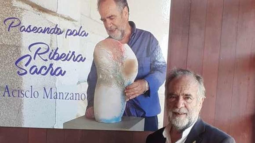 Acisclo Manzano, junto al cartel, con una de sus obras. // FdV