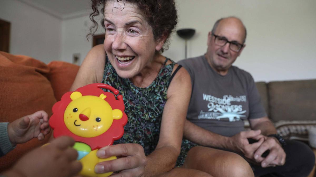 Emma Alonso-Vega Álvarez juega con su bebé de acogida, junto a ella, su marido, Ángel López Fernández