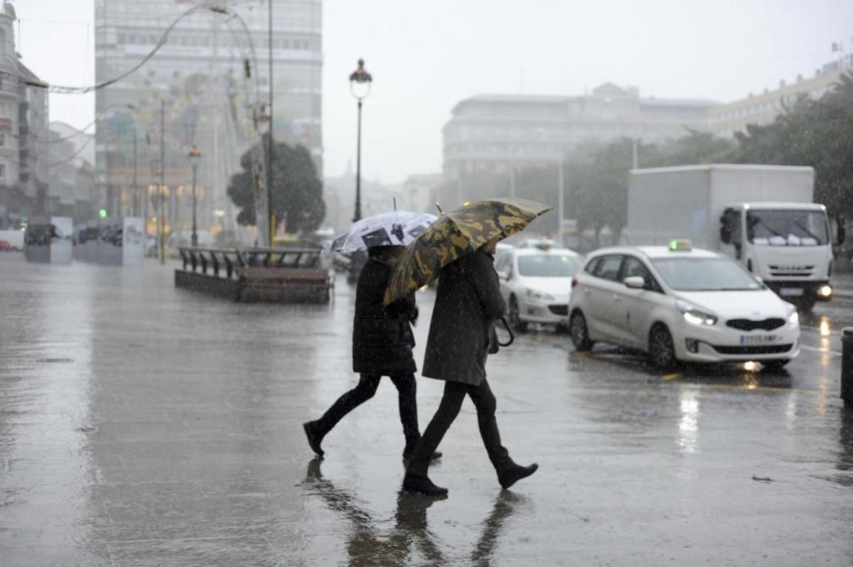 Dos personas con paraguas en los Cantones durante una jornada lluviosa en A Coruña.