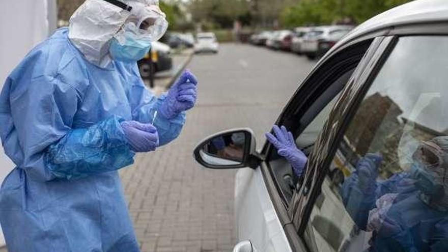 Un sanitario recoge una muestra en el aparcamiento.