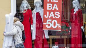 LOGROÑO 11/01/2026.- Una mujer pasa por delante del escaparate de una tienda que anuncia descuentos de hasta el 50%, este domingo en Logroño. El fin de la Navidad, marcado por el día de Reyes, es también el inicio del periodo de rebajas, que supone un balón de oxígeno para el pequeño comercio riojano. EFE/ Raquel Manzanares