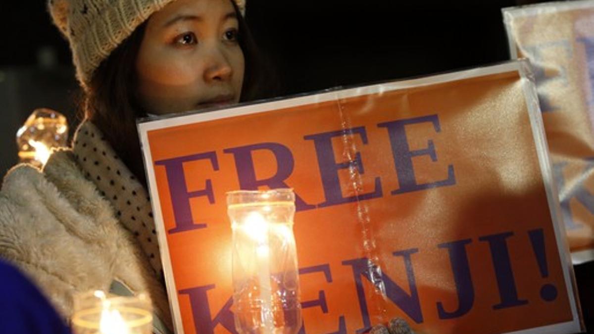 Una chica sostiene una vela en la marcha frente a la residencia del primer ministro japonés para pedir la liberación del periodista Kenji Goto, este viernes.