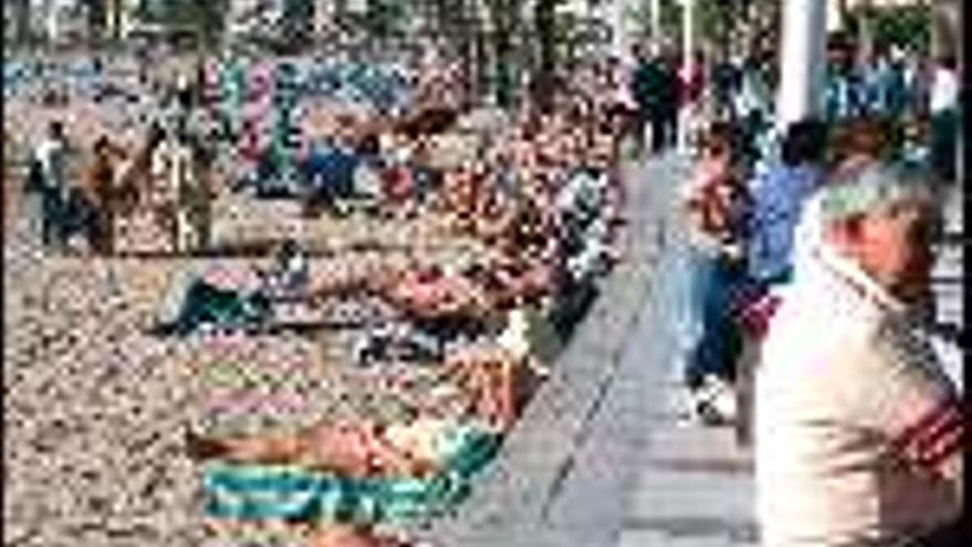 Un grupo

 de turistas toma del sol en la playa de Levante (Benidorm); en una imagen de este invierno