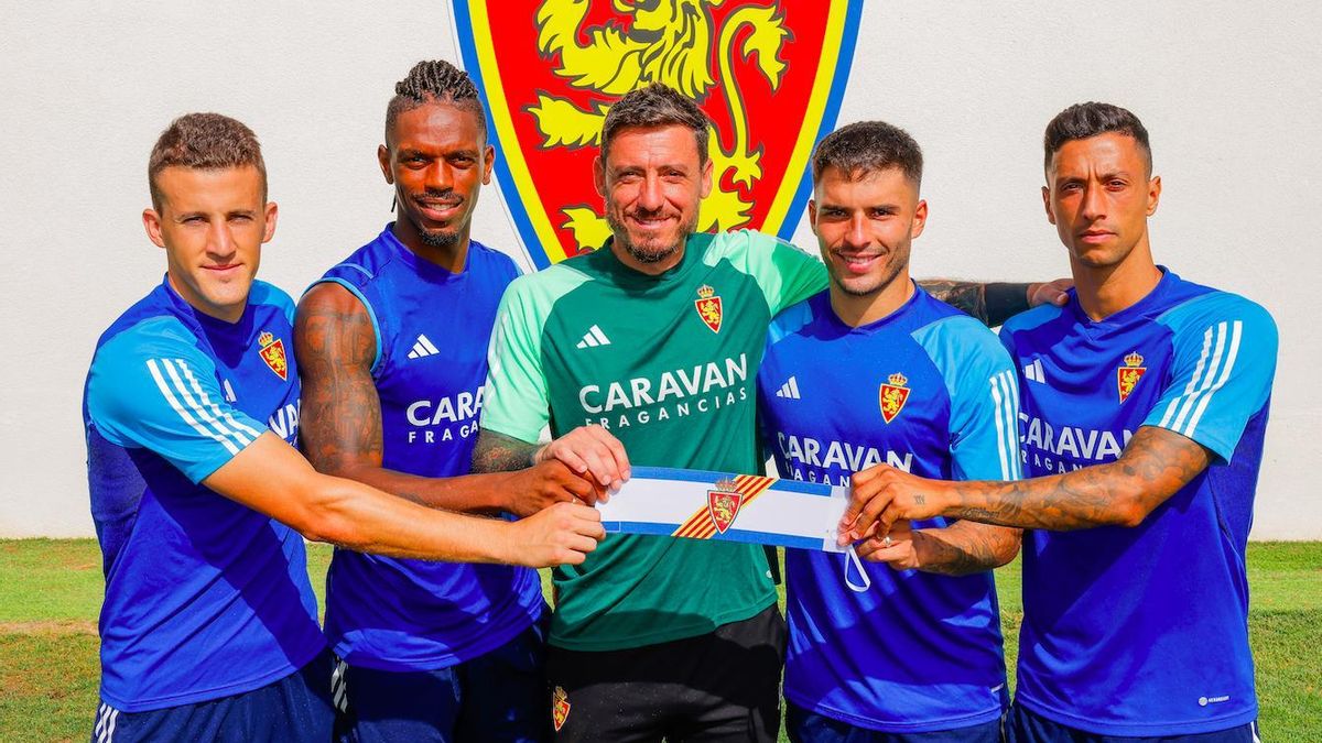 Nieto, Jair, Cristian Álvarez, Lluís López y Maikel Mesa, los cinco capitanes de la temporada 2023-24, sujetan el brazalete junto al escudo del Real Zaragoza.