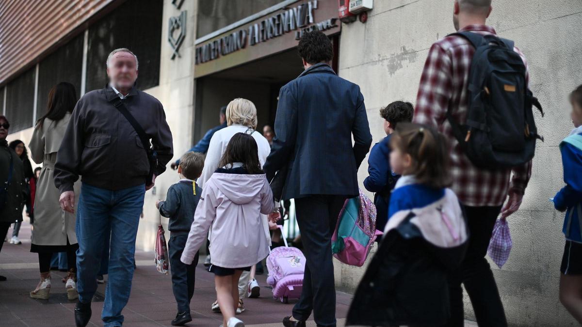 Padres con sus hijos, a la entrada de un colegio.