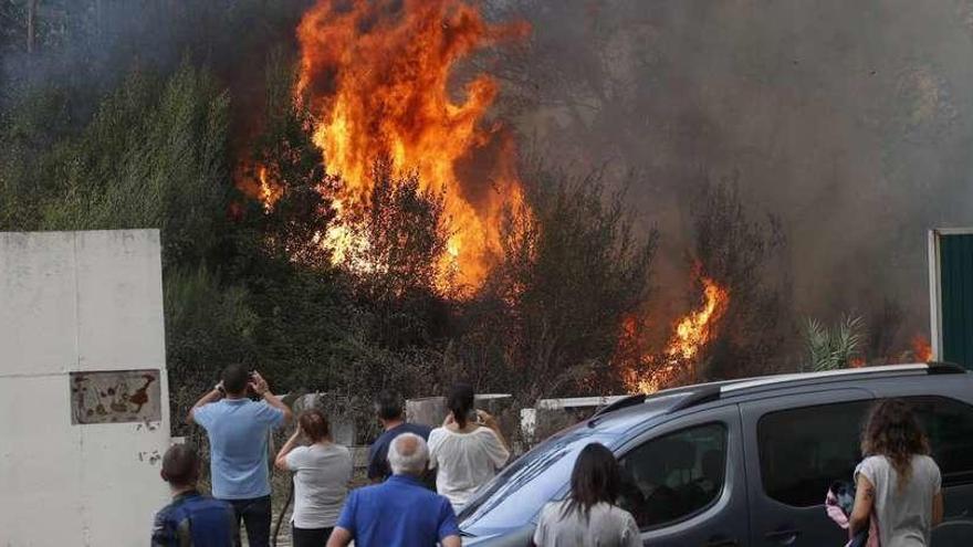 Unos vecinos observan el avance del fuego en la zona de Reboreda, en Redondela.