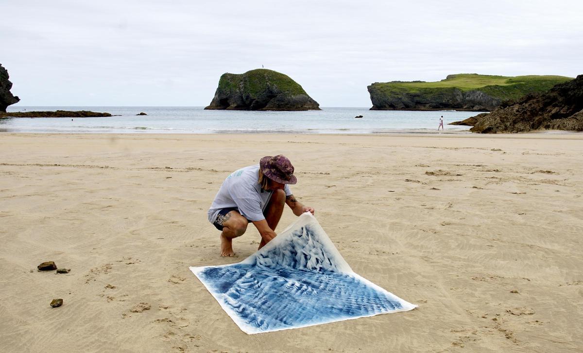 Iyán Castaño prepara una de sus obras en una playa de Llanes.
