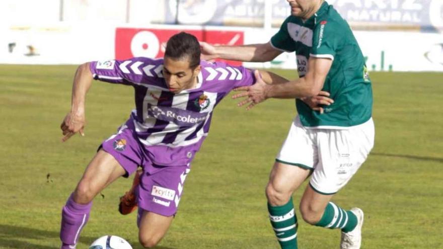 Pedro Vázquez, autor de los tres goles del Coruxo, trata de frenar a un rival en un lance del partido de ayer. // José Lores