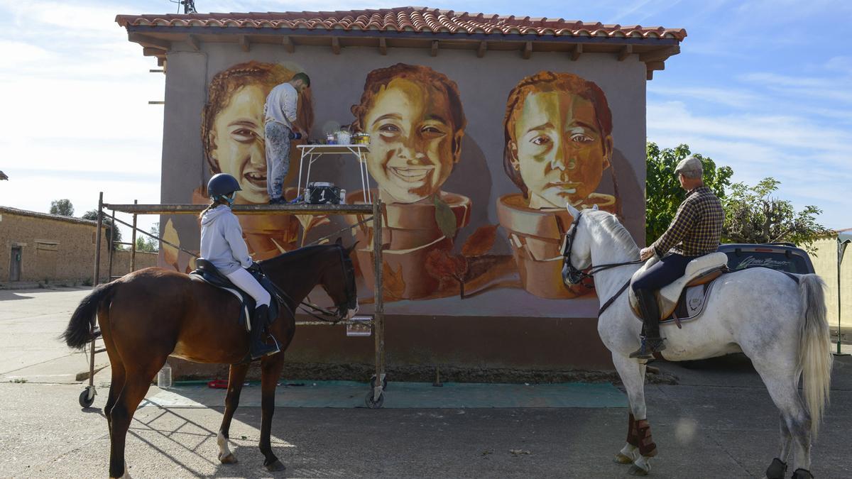 Dos caballistas observan el mural de Soen Bravo en Paladinos del Valle.