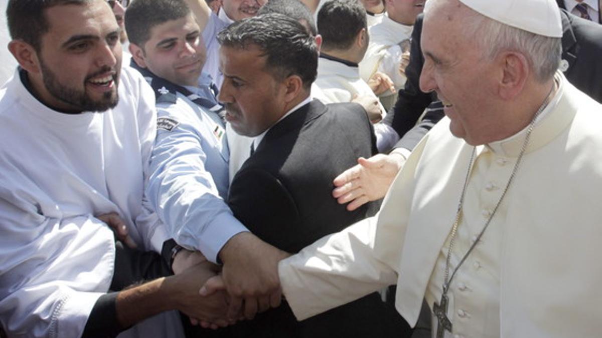El Papa saluda a un joven sacerdote, este sábado, antes de la misa en el estadio de Amán.