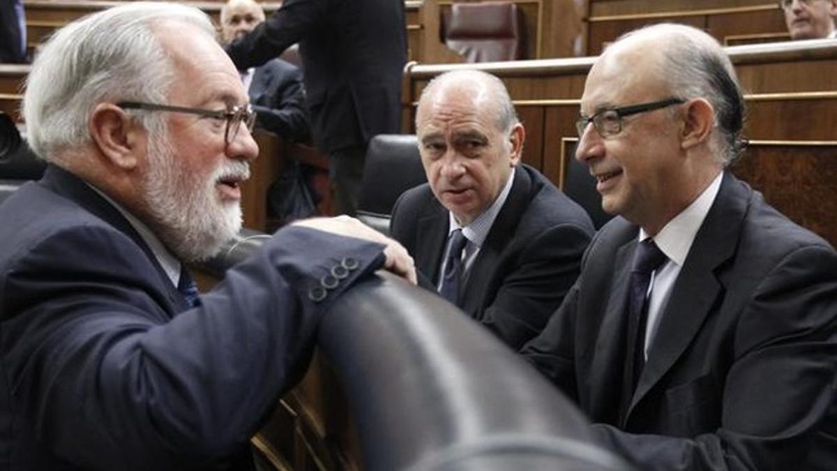 El ministro de Hacienda, Cristóbal Montoro (derecha), junto al titular de Interior, Jorge Fernández Díaz, y frente al de Agricultura, Miguel Arias-Cañete, este miércoles, 22 de mayo, en el Congreso. EFE / FERNANDO ALVARADO