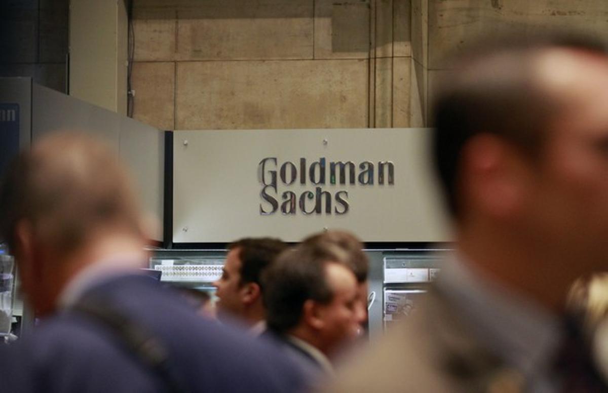 Diversos ’brokers’ passen davant el logo de Goldman Sachs a la Borsa de Nova York.