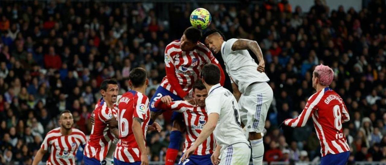 Jugadores de Real Madrid y Atlético disputan un balón aéreo.