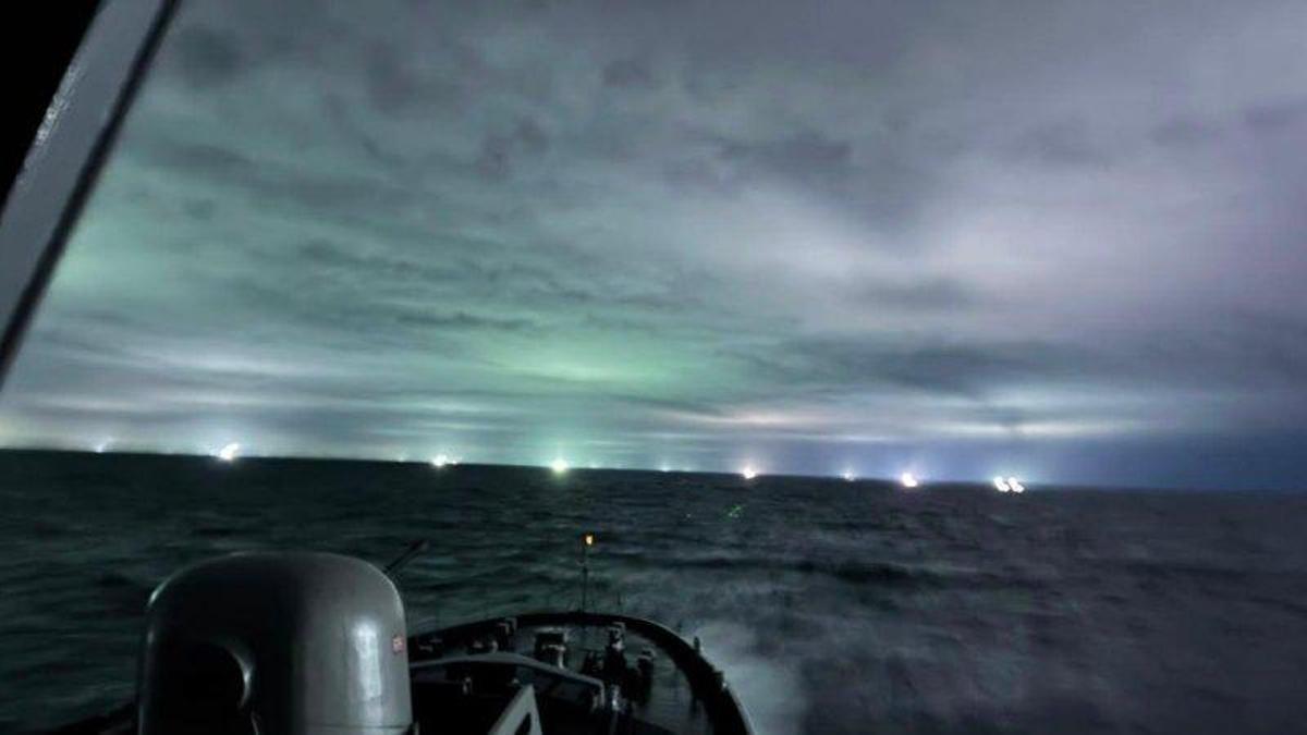 Un buque de la Armada de Chile, con decenas de poteros asiáticos a su proa.