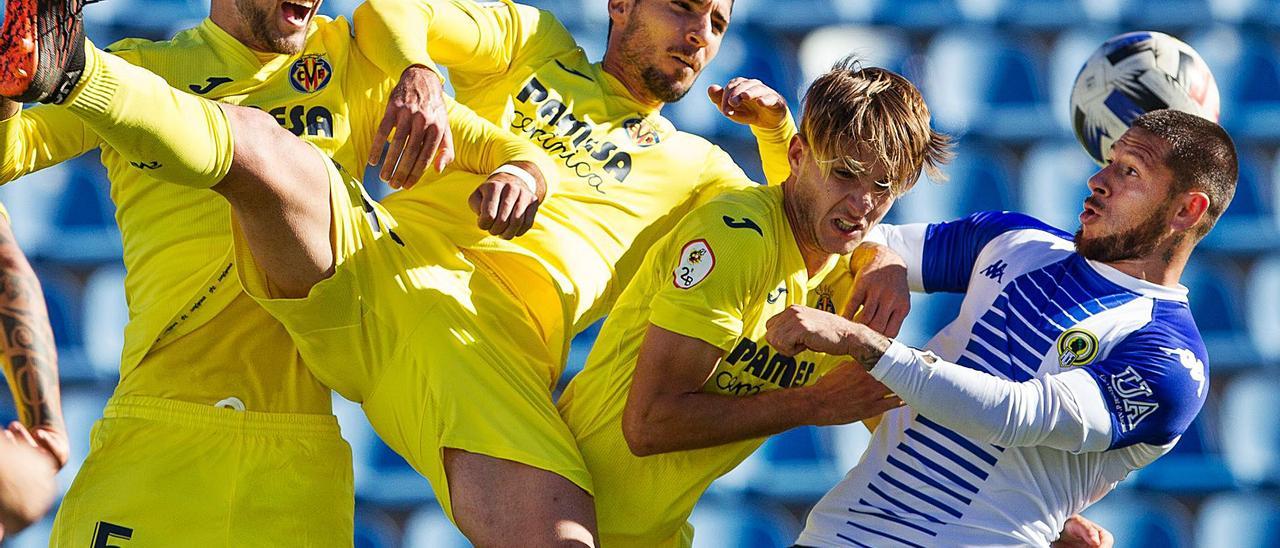 El delantero del Hércules Toro Acuña, que reaparece hoy en Villarreal, pugna con varios jugadores del filial en el partido de la primera vuelta.