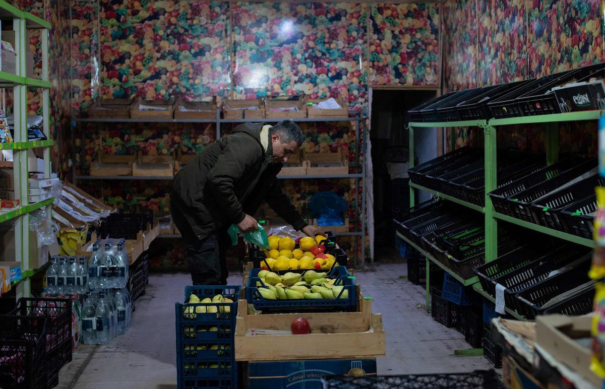 Un hombre sostiene una fruta en un mercado vacío en Stepanakert, capital de la autoproclamada región de Nagorno-Karabaj en Azerbaiyán, el 23 de diciembre de 2022.