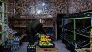 Un hombre sostiene una fruta en un mercado vacío en Stepanakert, capital de la autoproclamada región de Nagorno-Karabaj en Azerbaiyán, el 23 de diciembre de 2022.