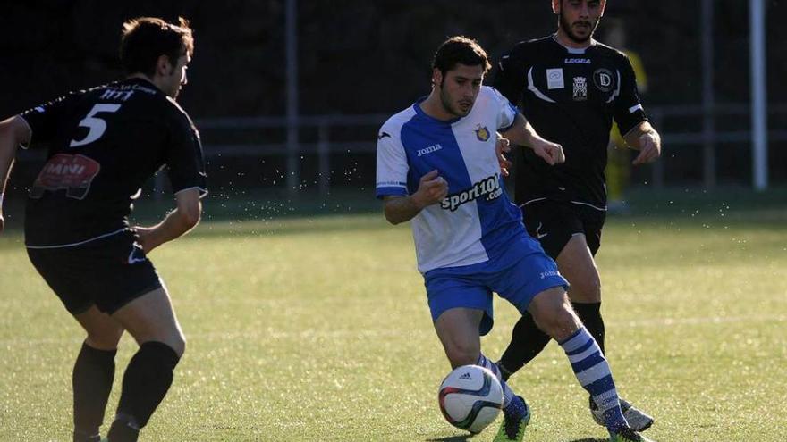 El jugador del Tuilla Villa, con el balón, entre Adolfo, a la izquierda, y Herrero.