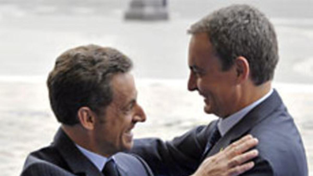 Sarkozy (izquierda) y Zapatero se saludan, hoy en París.