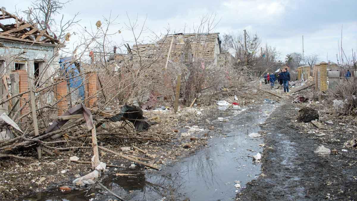 Un grupo de gente camina cerca de casas destruidas y escombros tras los bombardeos en el área de Sumy, en Ucrania