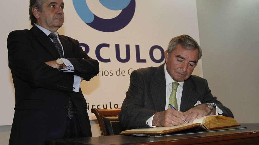 El presidente del Círculo de Empresarios, Javier Vega, durante la firma ayer del libro de honor de la organización que preside su homólogo en Vigo, Juan Güell, a su derecha. // José Lores