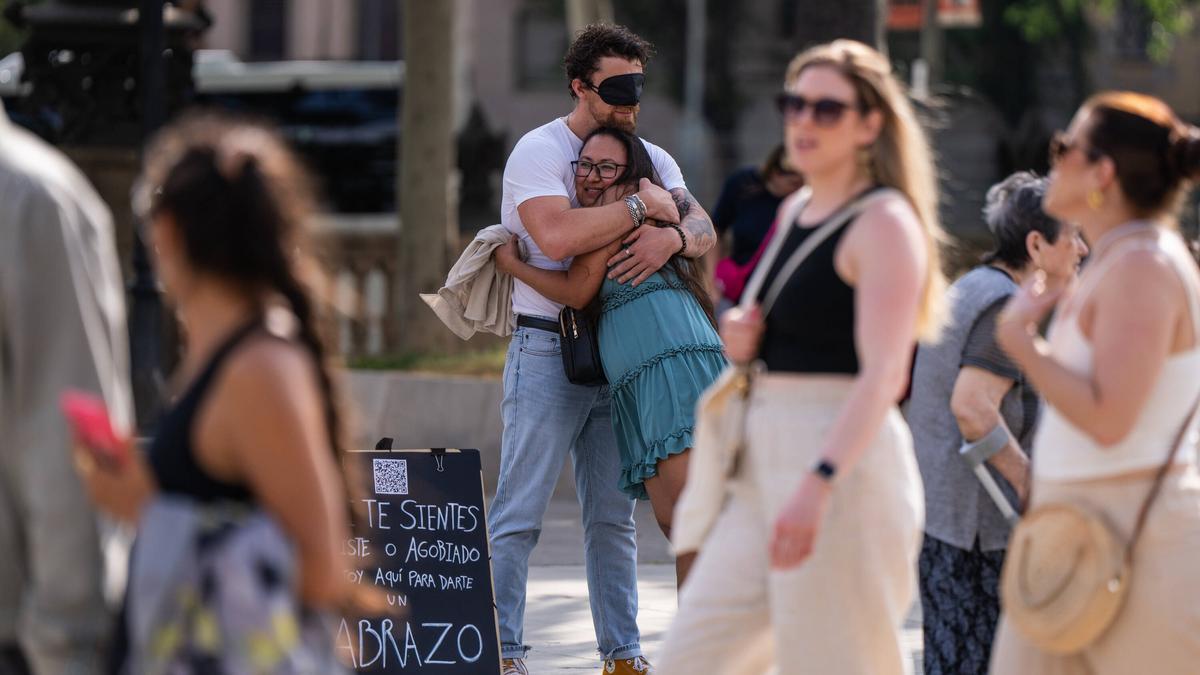 Abrazo callejero entre viandantes.