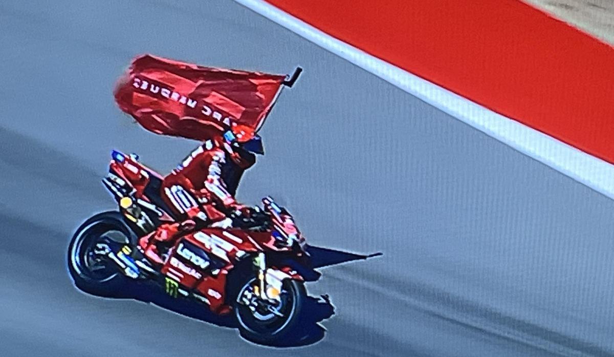 Marc Márquez (Ducati) pasea, como vencedor hoy en Motorland, la bandera de su clubs de fans.