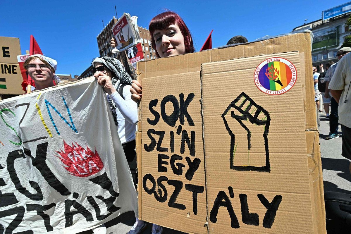 Un participante posa con una pancarta que dice Muchos colores son una clase durante la marcha del Orgullo de Budapest, el 28 de junio de 2025, a pesar de la prohibición gubernamental del evento.