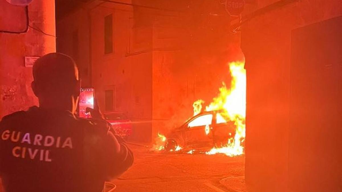 Ein Beamter der Guardia Civil filmt ein brennendes Auto in Porreres-