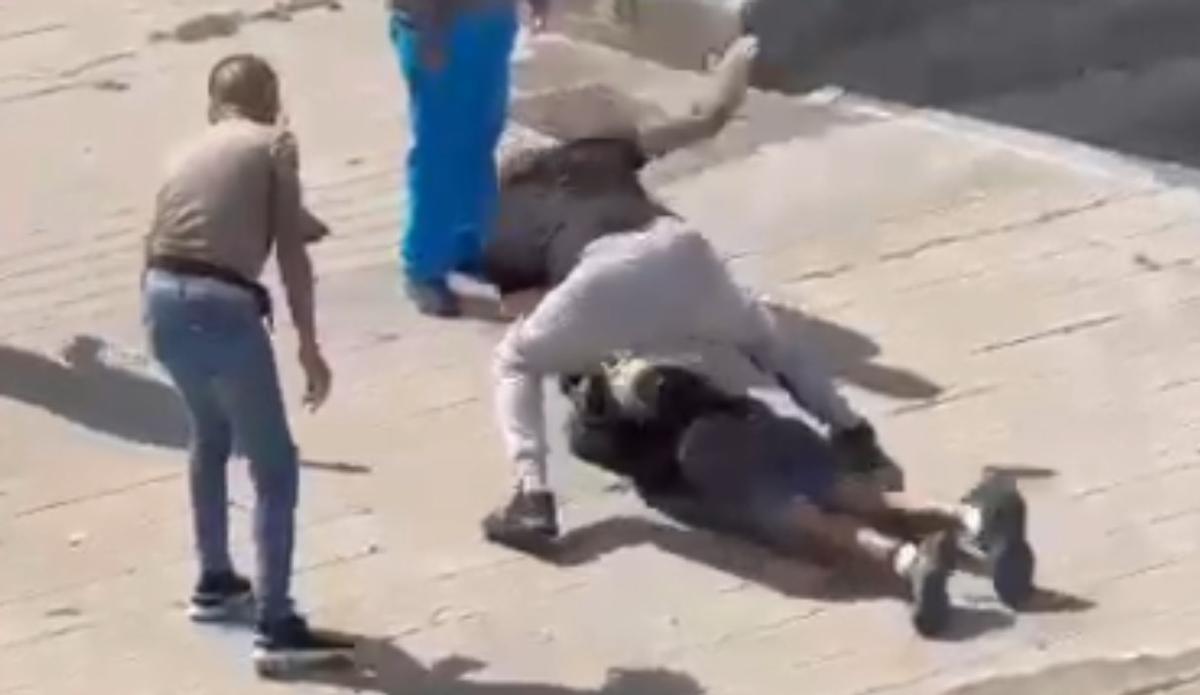 Un momento de la agresión, cuando uno de los hombres asesta varios golpes en la cabeza al otro.