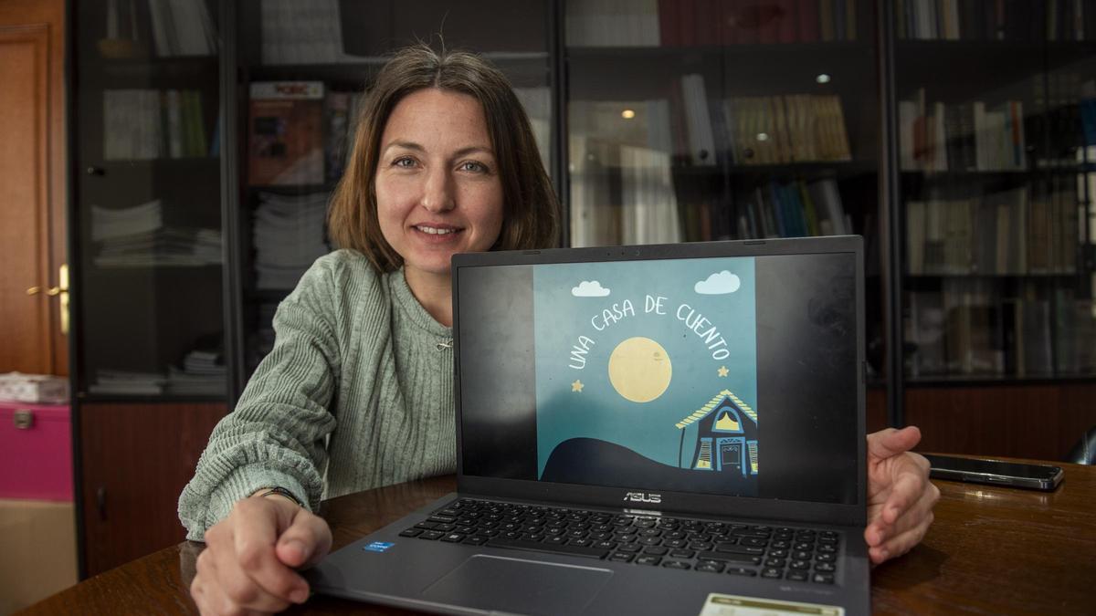 La logopeda Tania Varela, secretaria de la asociación O Son da Palabra (OSPA), junto a un ordenador portátil con la portada del videocuento inclusivo realizado por la asociación.