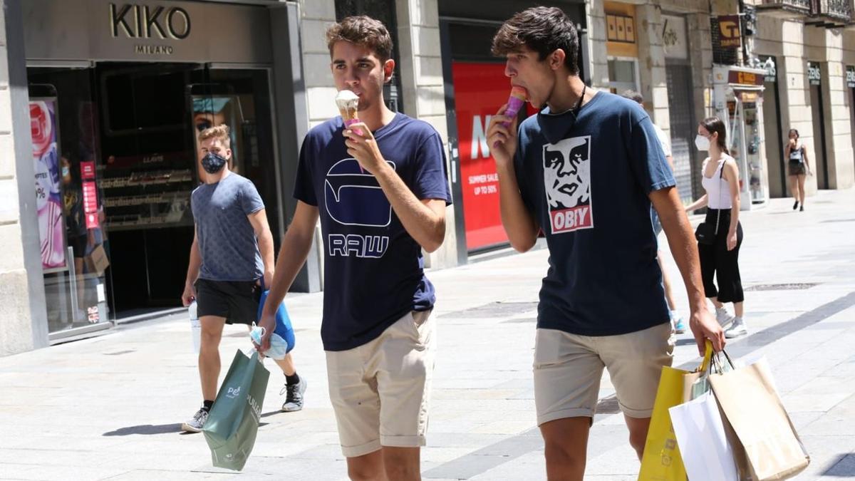 Unos chicos se toman un helado, en una calle del centro de Barcelona.