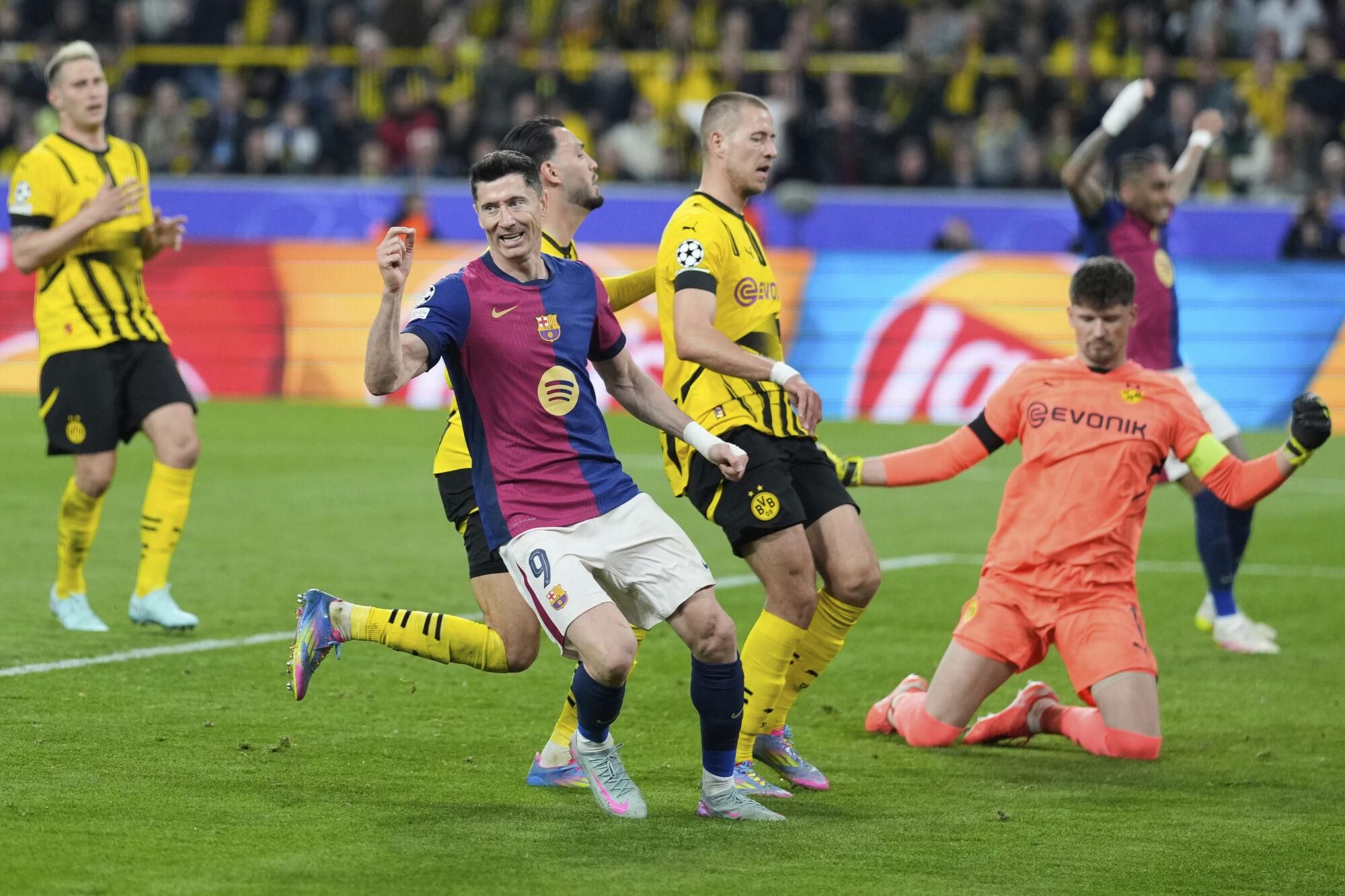Barcelona's Robert Lewandowski (9) celebrates after forcing an own goal by Dortmund's Ramy Bensebaini during the Champions League quarterfinals second leg soccer match between Borussia Dortmund and Barcelona, at the Signa-Iduna Park in Dortmund, Germany, Tuesday, April 15, 2025. (AP Photo/Matthias Schrader). EDITORIAL USE ONLY/ONLY ITALY AND SPAIN